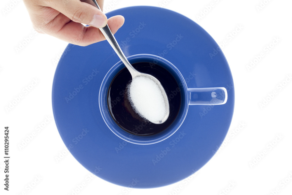 cropped view of a human hand with spoon of sugar over coffee cup. cropped view of a human hand with spoon of sugar over coffee cup.