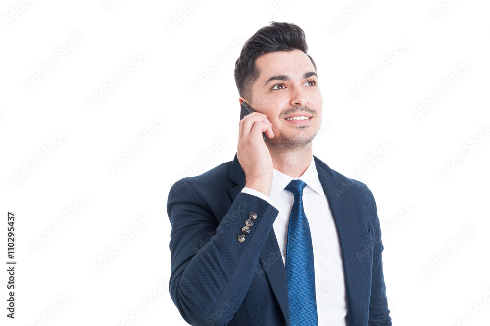 Confident young businessman calling on smartphone and smiling Confident young businessman calling on smartphone and smiling