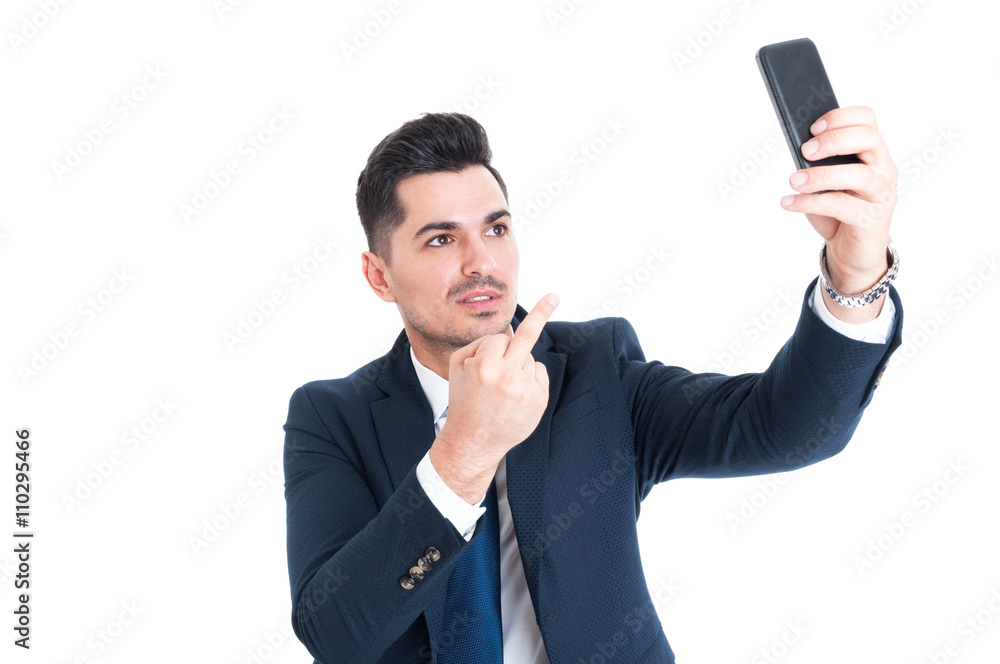 Businessman taking a selfie and showing middle finger Businessman taking a selfie and showing middle finger