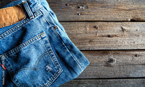 Neatly folded jeans on wooden background. Clothing, fashion, style, lifestyle