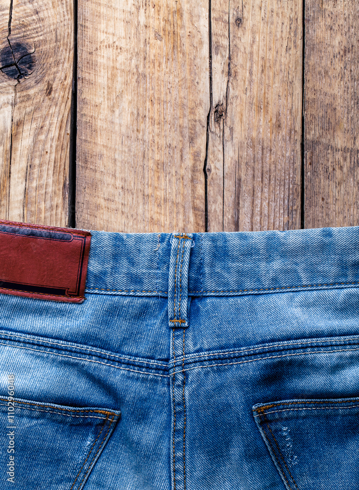 Jeans on a wooden background. The upper part. Clothing, fashion, style, lifestyle Jeans on a wooden background. The upper part. Clothing, fashion, style, lifestyle