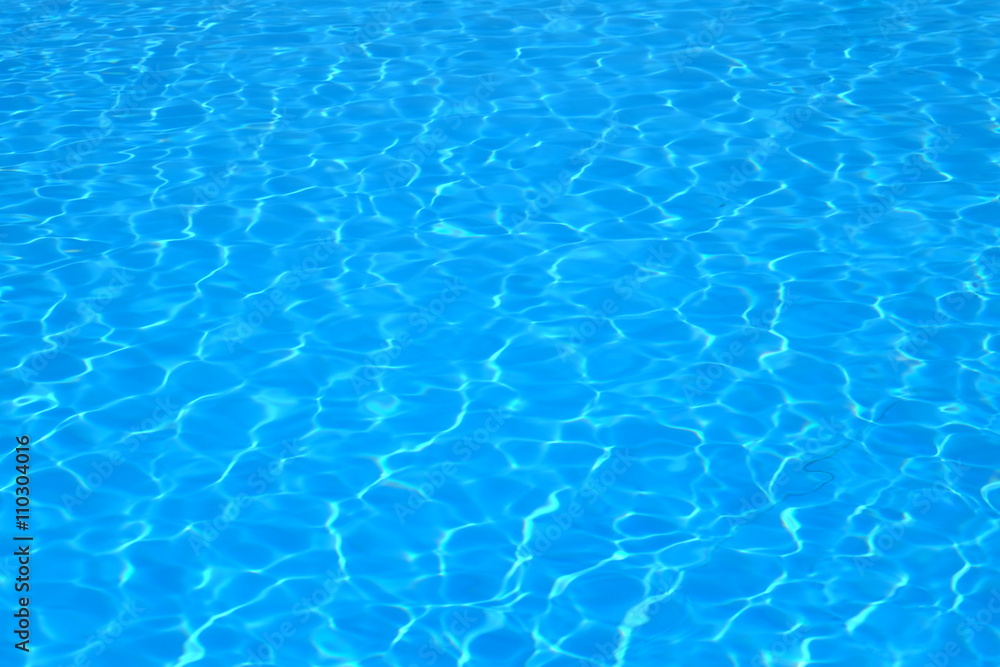 Blue and bright water with sun reflection in swimming pool