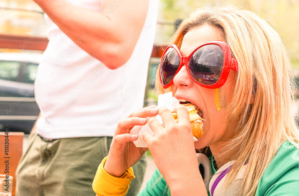 Starving woman eating beef burger outside - Hungry girl biting hamburger at cafe bar restaurant outdoor - Concept of modern nutrition and bad health care habits Starving woman eating beef burger outside - Hungry girl biting hamburger at cafe bar restaurant outdoor - Concept of modern nutrition and bad health care habits