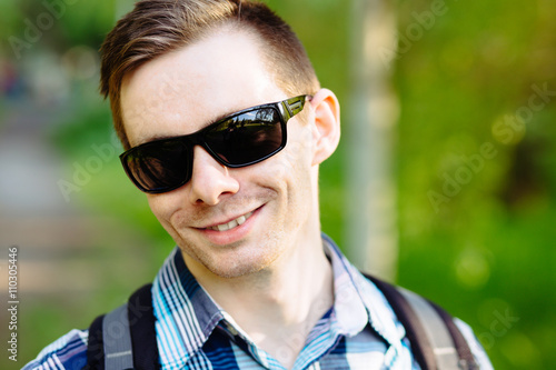 Portrait of attractive young man in sunglasses at park