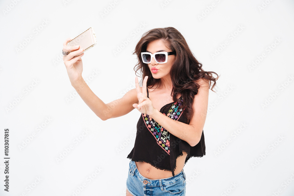 Woman making selfie photo and showing peace sign Woman making selfie photo and showing peace sign