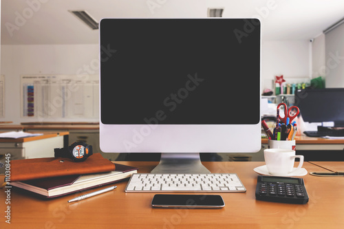 office workplace with modern computer on wooden table, vintage tone [blur and selective focus background]