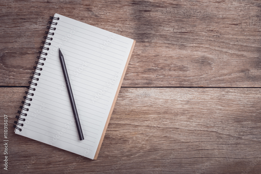 Notepad / lined paper on wooden table top view Notepad / lined paper on wooden table top view