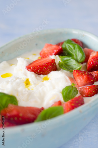 Fototapeta Naklejka Na Ścianę i Meble -  Creamy stracciatella with strawberries, basil and olive oil. Selective focus.
