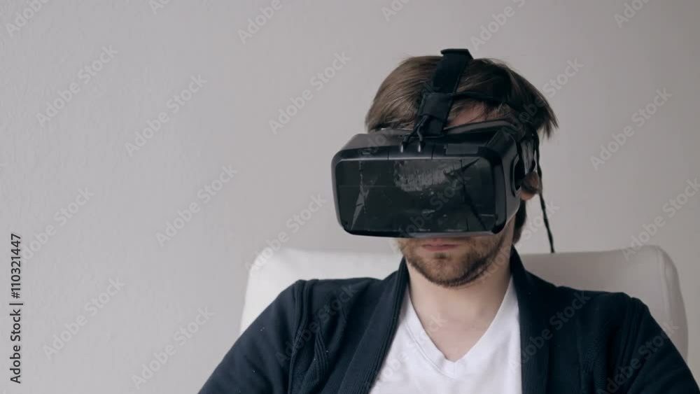 Young Man Experiencing Virtual Reality Through a VR Headset isolated on white background Young Man Experiencing Virtual Reality Through a VR Headset isolated on white background