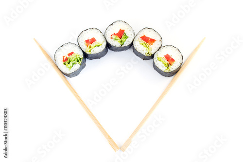 Sushi between chopsticks for sushi isolated on white background. Top view. 