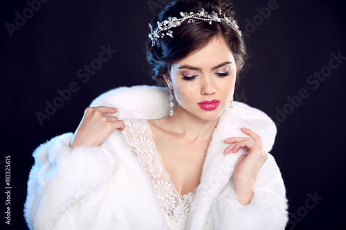 Foto Fashion portrait of beautiful young woman in white fur coat with