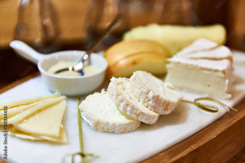 Soft cheese Buche on wooden board at dinner table Soft cheese Buche on wooden board at dinner table
