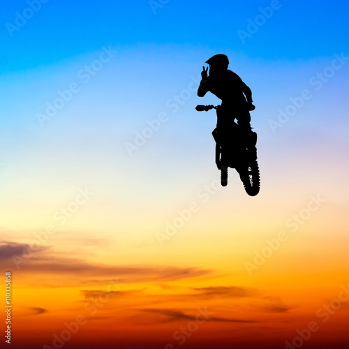 silhouette of motocross rider jump in the sky at sunset