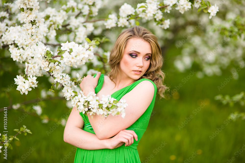 Beautiful happy young woman in spring blossoming garden Beautiful happy young woman in spring blossoming garden