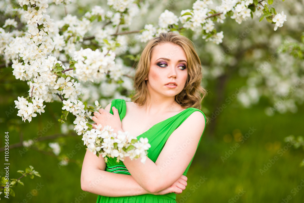 Beautiful happy young woman in spring blossoming garden Beautiful happy young woman in spring blossoming garden