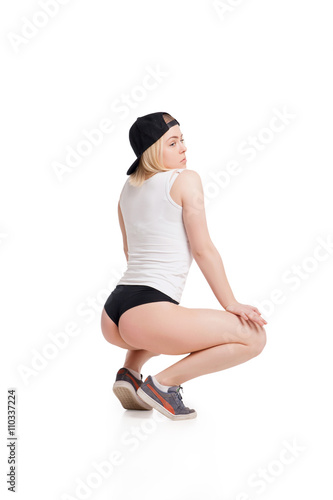 Female model in tank top and briefs squating on haunches isolated