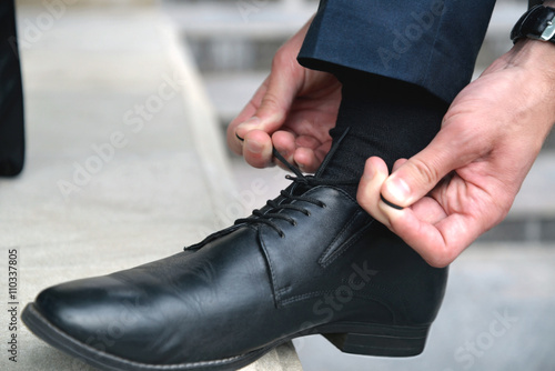 Man’s hands tying shoes