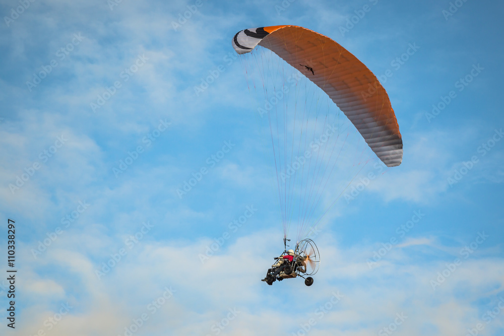 The motorized hang glider in the blue sky