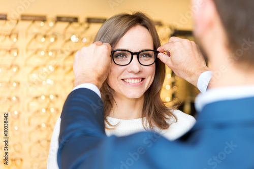 Fototapeta Naklejka Na Ścianę i Meble -  Young attractive  woman testing new glasses with optician