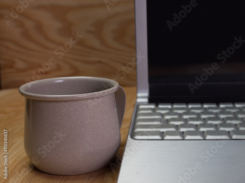 Computer  and cup of coffee on  wooden desk.
