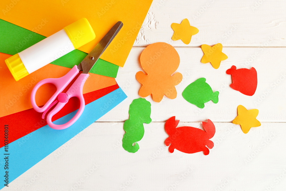 Sheets of colored paper, scissors, glue, paper fish and sea creatures. DIY  concept. Kids craft idea Stock Photo