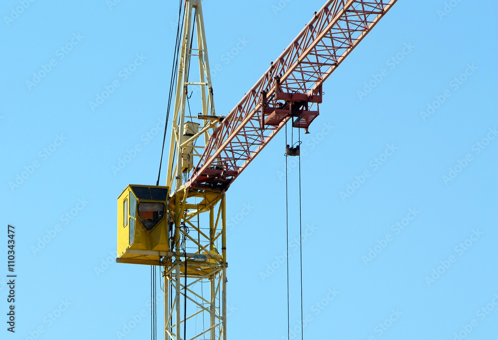 Cranes building against the blue sky. Heavy construction equipment. 