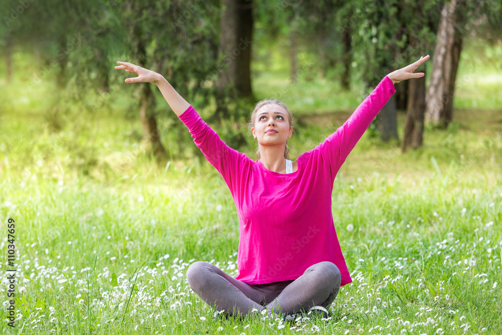 Woman meditating in park Woman meditating in park