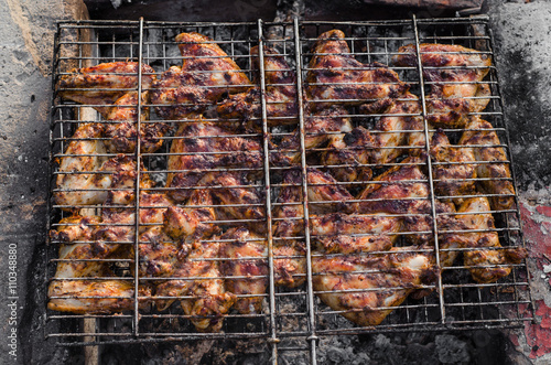Closeup Grilled chicken wings barbecue on grid over charcoal. Selective focus