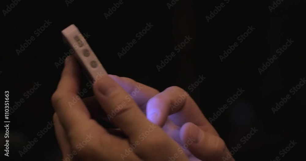 Close-up shot of man using smart phone in the bus at night, window with passing city lights in background Close-up shot of man using smart phone in the bus at night, window with passing city lights in background