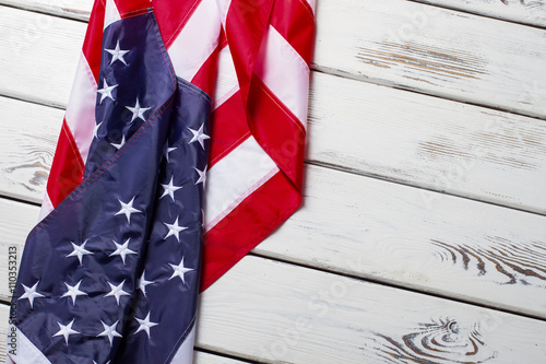 Fototapeta Naklejka Na Ścianę i Meble -  Crumpled USA flag. USA flag on wooden background. Banner laying on white shelf. Greetings from land of opportunity.
