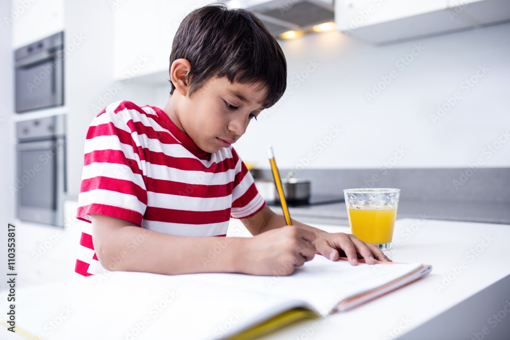 Portrait of boy doing homework in kitchen Portrait of boy doing homework in kitchen