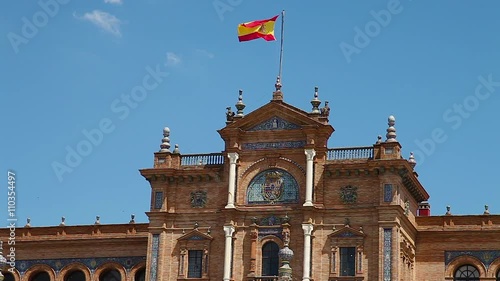 Central palace building   with spanish flag waving in Plaza de Espana square in Seville city