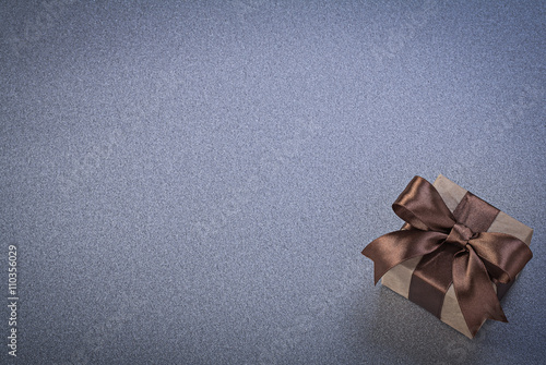 Boxed present with brown tape on grey background copy space cele