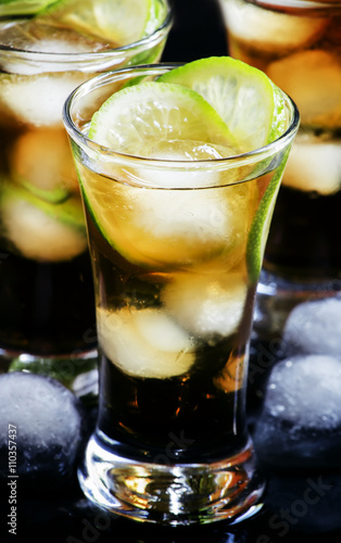 Alcoholic cocktail spiced rum with cola, lime and ice cubes, sha