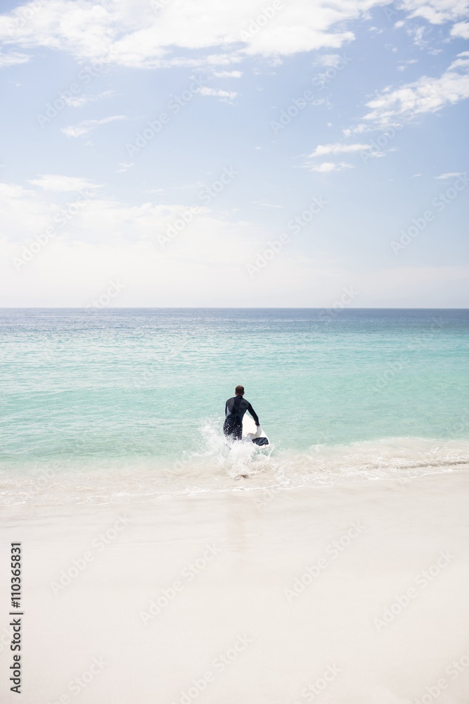 Surfer running towards sea with a surfboard Surfer running towards sea with a surfboard
