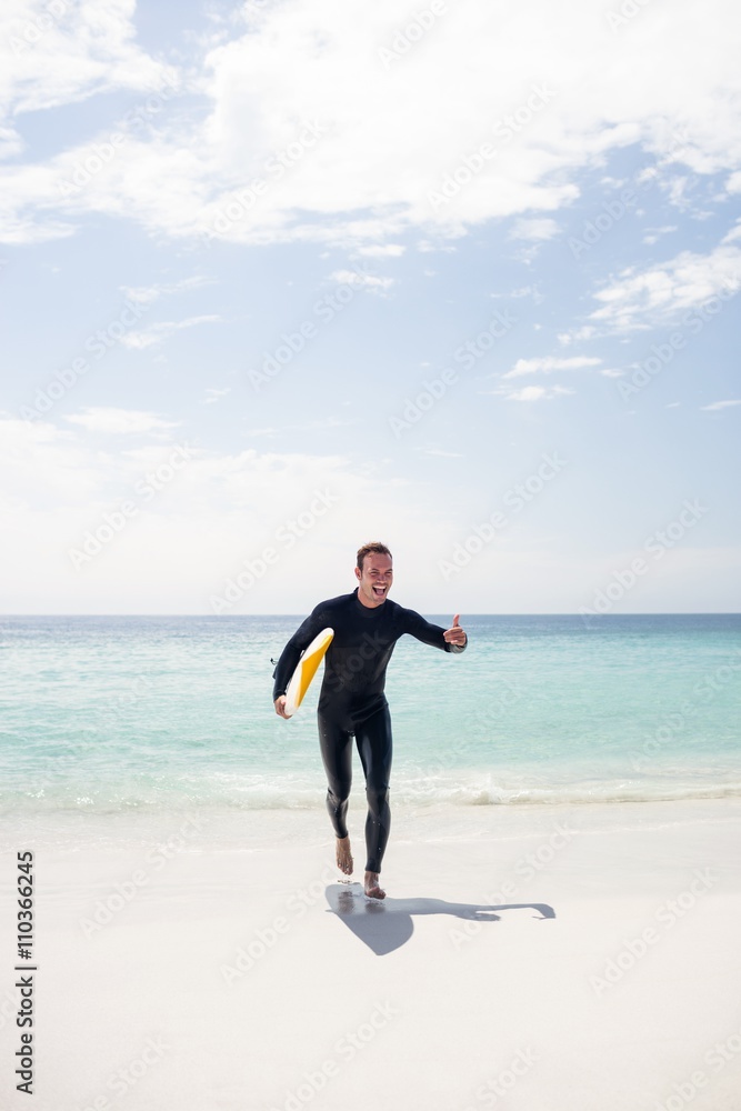 Surfer running on the beach with a surfboard Surfer running on the beach with a surfboard