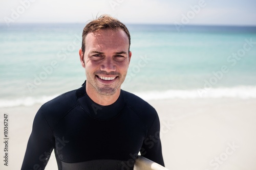 Happy surfer standing on beach