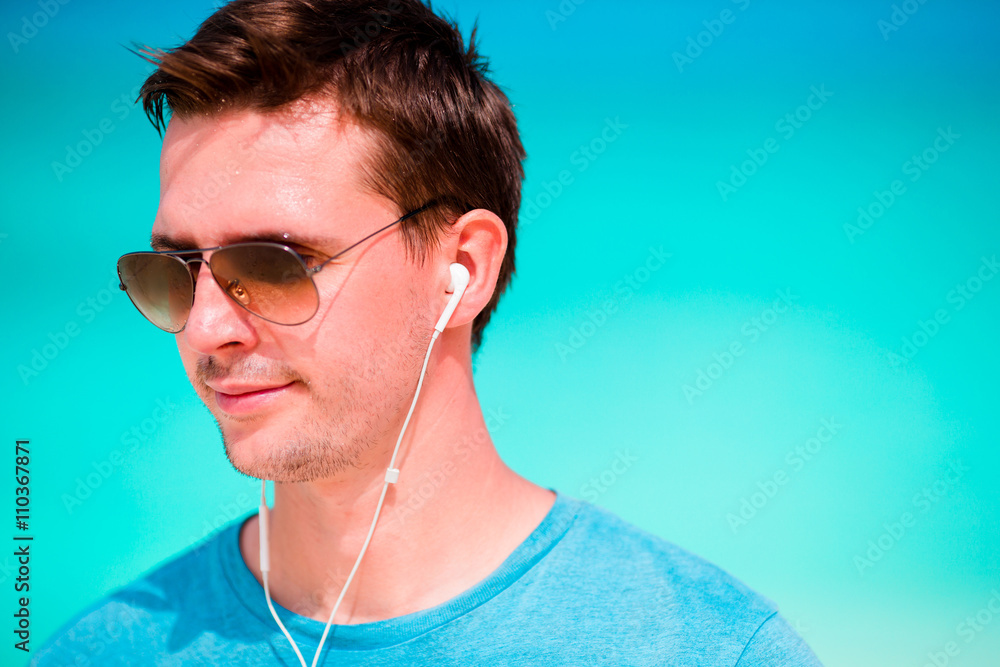 Happy man enjoying the music on white sandy beach Happy man enjoying the music on white sandy beach