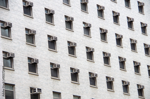 White brick building detail of window and air conditioner pattern