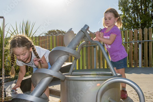 Girls playing with a water pump. photo