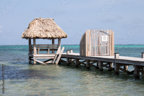 Pier in Belize with gate and thatched roof