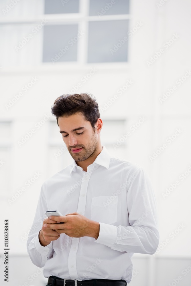 A businessman is looking his smartphone and texting