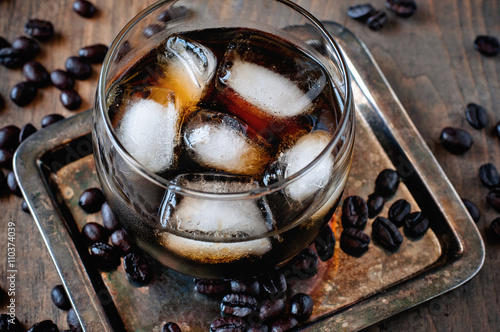 Kahlua liqueur in glasses with coffee beans on a wooden background, selective focus