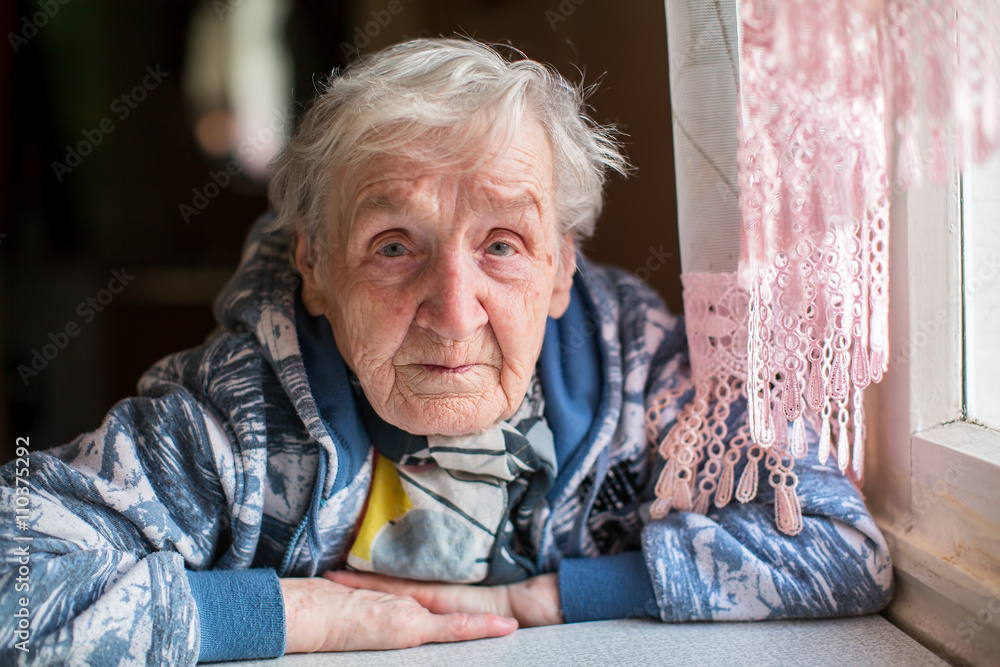 Sad elderly woman portrait at the table. Sad elderly woman portrait at the table.