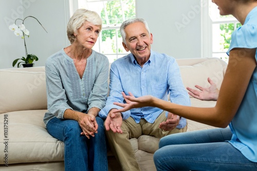 Female consultant explaining senior couple at home