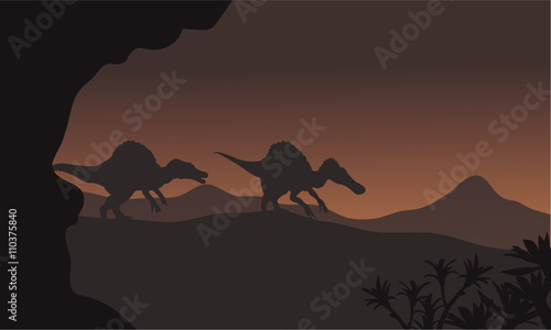Fototapeta Naklejka Na Ścianę i Meble -  Silhouette of two spinosaurus walking in hills