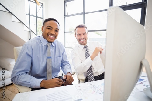 Businessmen smiling while at a meeting