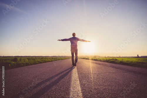 Man walking on the line on a paved road