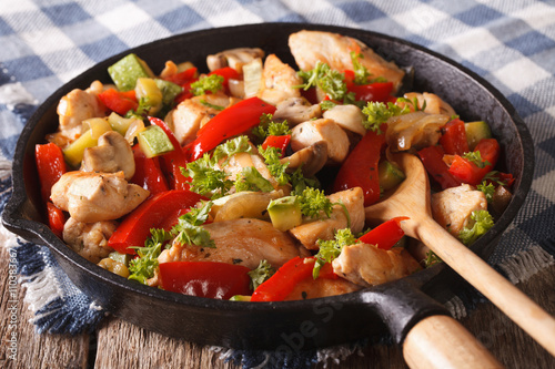 Chicken saute with mushrooms, peppers and zucchini closeup on a pan. horizontal
