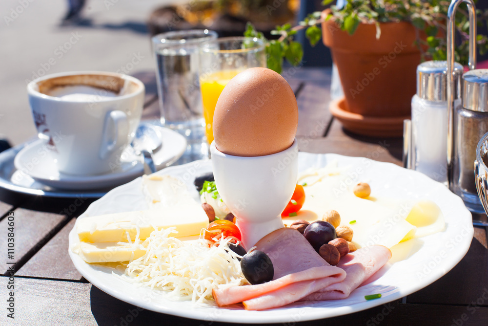 Fototapeta premium Breakfast consisting of orange juice, tomatoes, bread and egg. Balanced diet